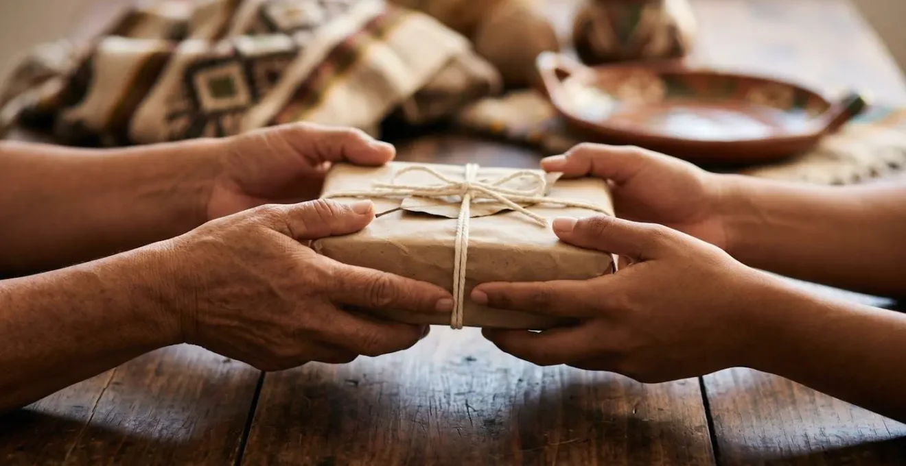 Mains échangeant un cadeau artisanal dans un geste de gratitude interculturelle