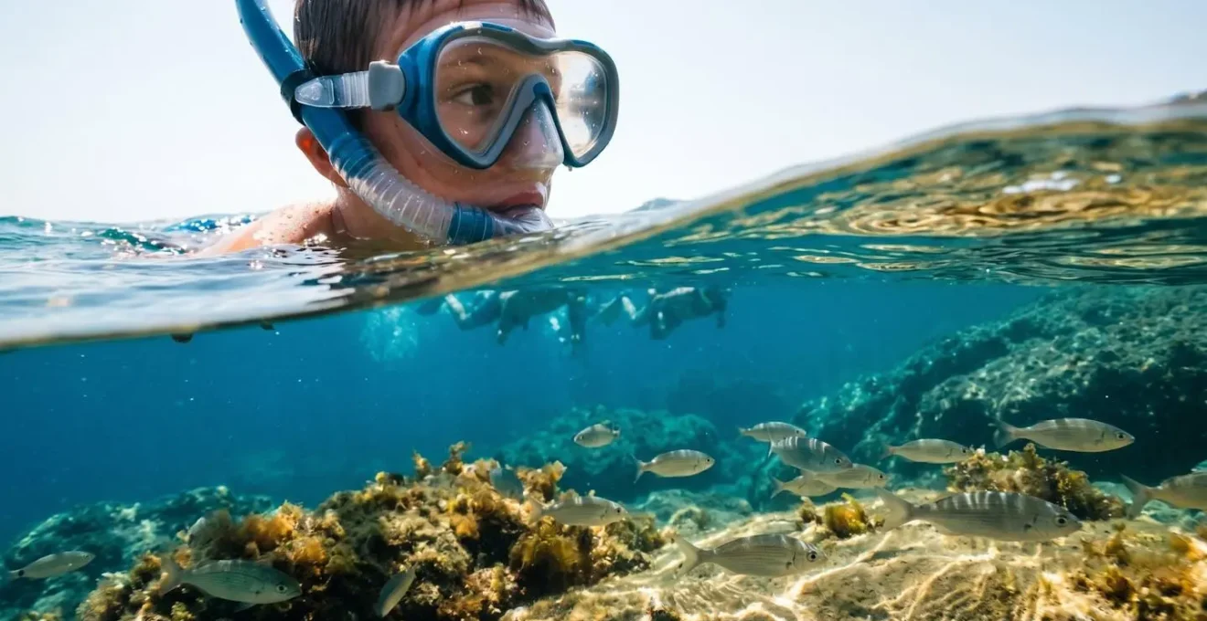Enfant explorant la vie marine méditerranéenne en snorkeling dans les eaux claires des Cyclades